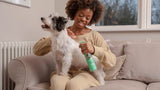 lady smiling with applying furtastic spray to her Terrier