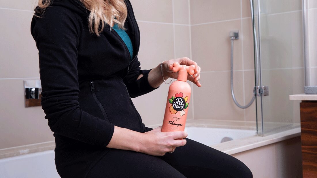 lady holding Quick Fox shampoo in her bathroom