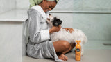 lady smiling at her dog after her shower with Ditch the Dirt shampoo in foreground