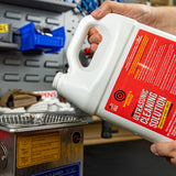 man pouring shooter's choice ultrasonic cleaning solution into ultrasonic cleaning device